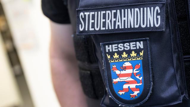 Im Rahmen einer Großrazzia gegen Schwarzarbeit durchsuchen Beamte des Zoll Firmenräume in Frankfurt. Dabei steht ein Beamter der Steuerfahndung bereit.