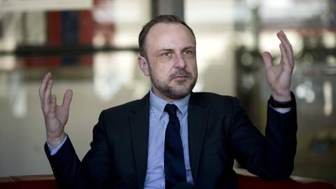 Peter Neumann gestikuliert während eines Gesprächs.