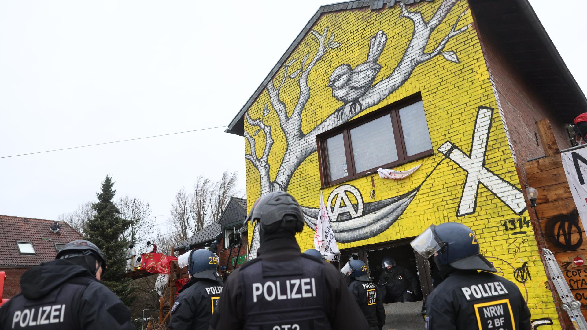 Polizisten verschaffen sich am zweiten Tag der Räumung im von Klimaaktivisten besetzten Braunkohleort Lützerath Zutritt zu einem Gebäude. 