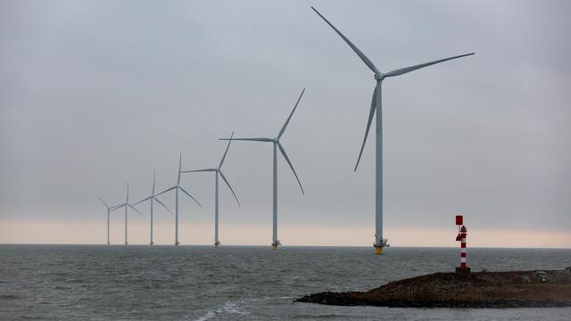 Auf dem Bild sind Offshore-Windkraftwerke in der Nordsee zu sehen. Sie stehen in einer schrägen Linie bis zum Horizont. Im Vordergrund ist eine Landzunge mit einem Leuchtturm. Auf dem Bild sind Offshore-Windkraftwerke in der Nordsee zu sehen. Sie stehen in einer schrägen Linie bis zum Horizont. Im Vordergrund ist eine Landzunge mit einem Leuchtturm.