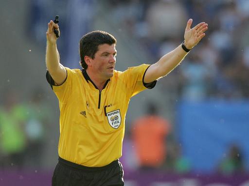 Herbert Fandel hier als Schiedsrichter in gelbem Shirt und Pfeife in der Hand beim International FIFA Confederations Cup 2005 in Griechenland.