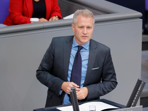 Ein Mann steht an einem Rednerpult im Bundestag.