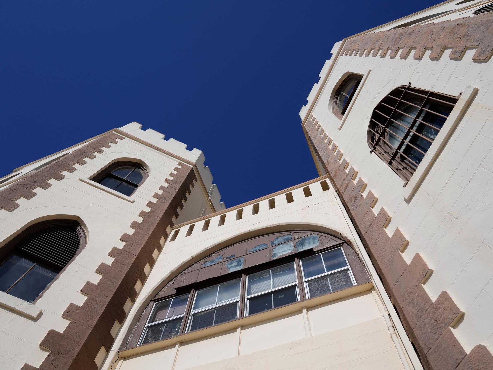 Blick auf die historischen Gebäudetürme von San Quentin, die sich in den blauen Himmel recken.