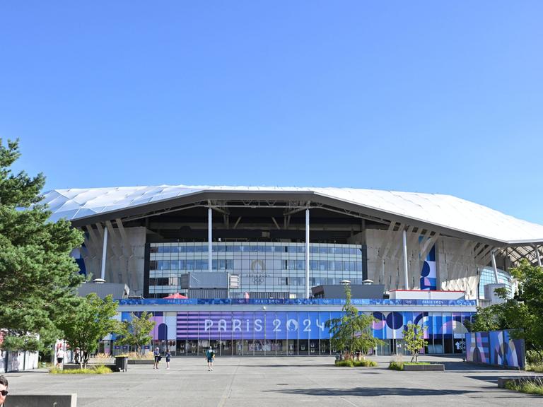 Außenaufnahme des Stadions in Lyon zur Olympiade 2024 vor blauem Himmel.