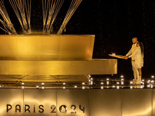 Marie-José Perec und Teddy Riner entzünden bei der Eröffnungsfeier der Olympischen Spiele in Paris das Olympische Feuer. 