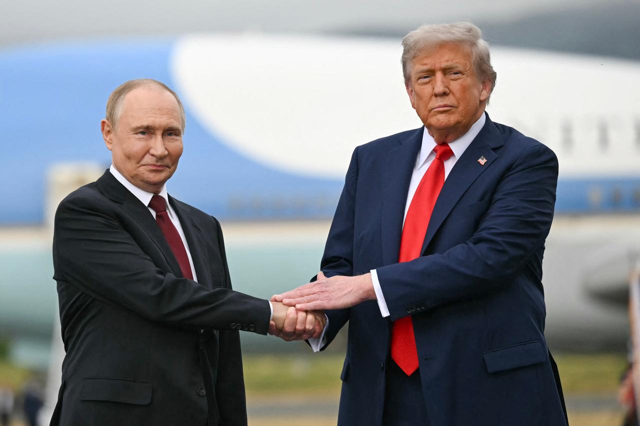 Trump und Putin reichen sich die Hand. Sie schauen in Richtung der Kamera. Trump und Putin reichen sich die Hand. Sie schauen in Richtung der Kamera.