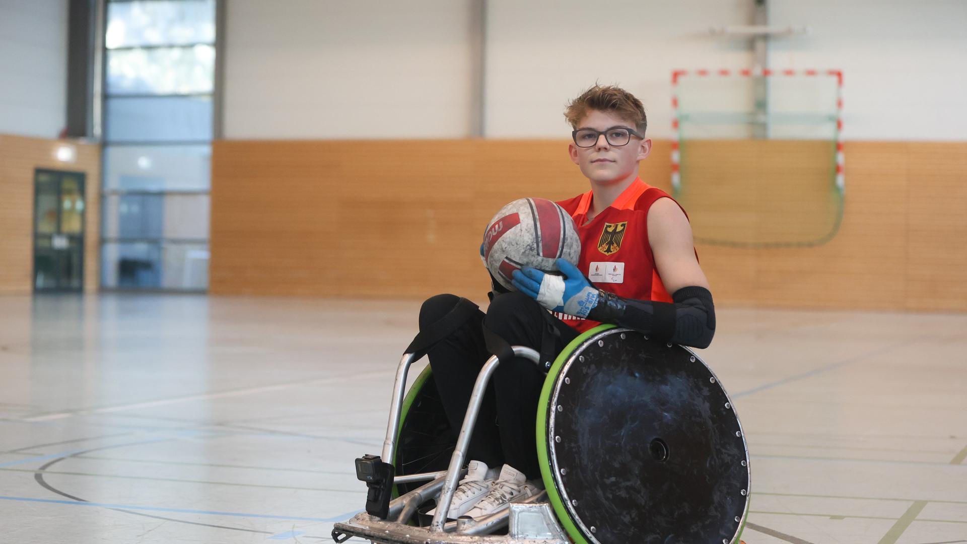 Jonte Küntzel sitzt in einem speziellen Rollstuhl und hält einen Ball in den Händen. Jonte Küntzel sitzt in einem speziellen Rollstuhl und hält einen Ball in den Händen.