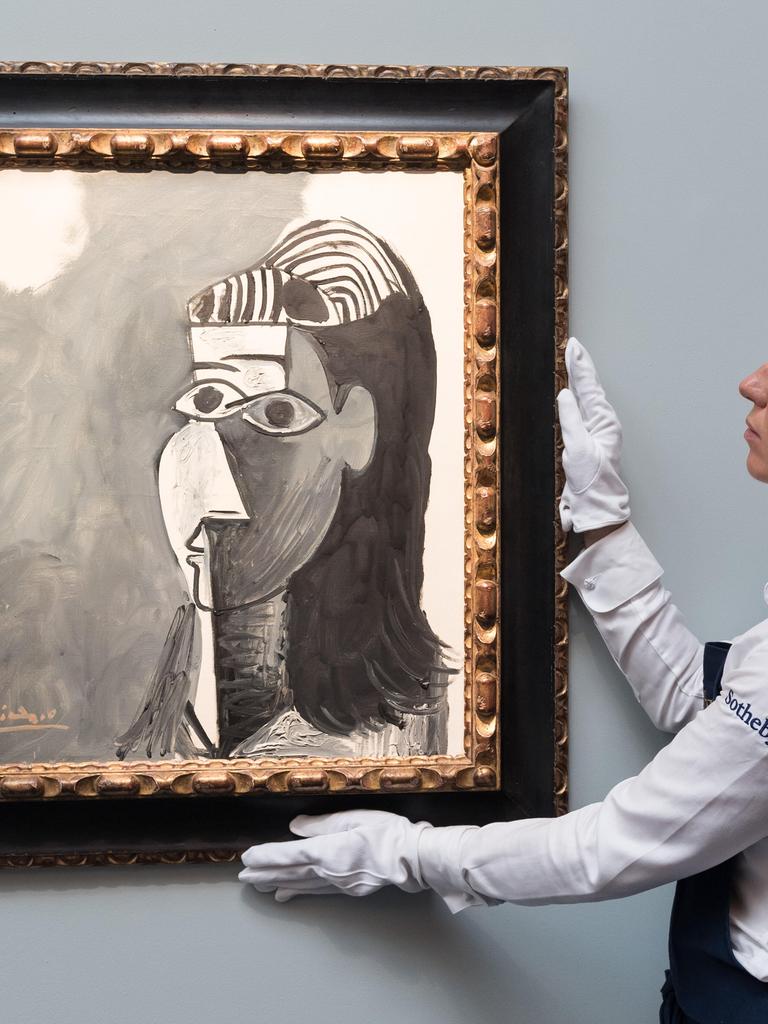 Eine Frau hält während einer Präsentation des Auktionshauses Sotheby's das Bild "Tete de femme" von Pablo Picasso