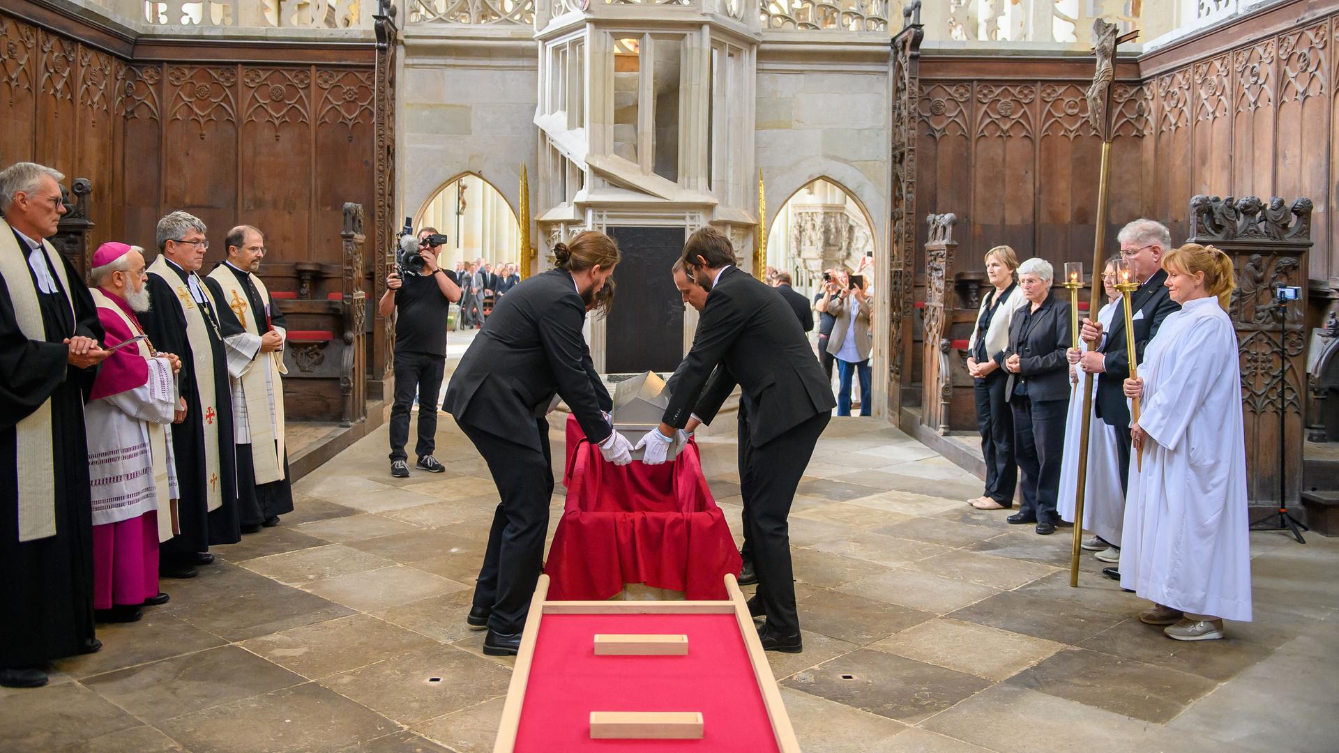 Mitarbeiter vom Landesamt für Denkmalpflege und Archäologie Sachsen-Anhalt und von der Kulturstiftung Sachsen-Anhalt heben im Hohen Chor des Doms den Sarg mit den Gebeinen von Kaiser Otto dem Großen in den Sarkophag. Mitarbeiter vom Landesamt für Denkmalpflege und Archäologie Sachsen-Anhalt und von der Kulturstiftung Sachsen-Anhalt heben im Hohen Chor des Doms den Sarg mit den Gebeinen von Kaiser Otto dem Großen in den Sarkophag.