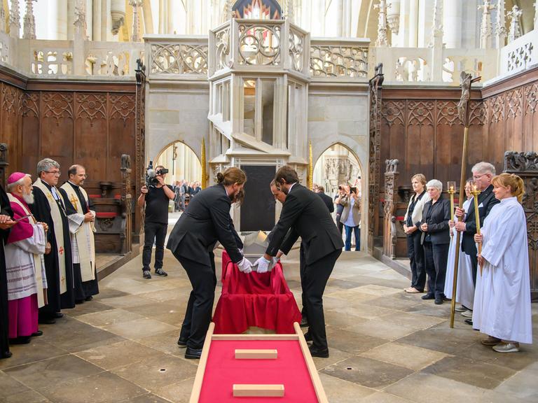 Mitarbeiter vom Landesamt für Denkmalpflege und Archäologie Sachsen-Anhalt und von der Kulturstiftung Sachsen-Anhalt heben im Hohen Chor des Doms den Sarg mit den Gebeinen von Kaiser Otto dem Großen in den Sarkophag. Mitarbeiter vom Landesamt für Denkmalpflege und Archäologie Sachsen-Anhalt und von der Kulturstiftung Sachsen-Anhalt heben im Hohen Chor des Doms den Sarg mit den Gebeinen von Kaiser Otto dem Großen in den Sarkophag.