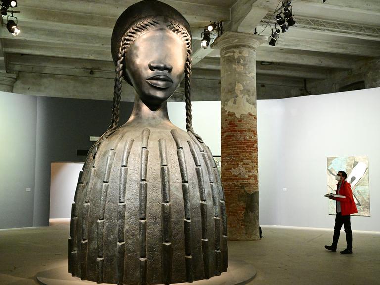 Ein Besucher sieht „Brick House“, eine Bronzeskulptur aus dem Jahr 2019 der Künstlerin Simone Leigh, während eines Pressetages auf der 59. Kunstbiennale in Venedig.