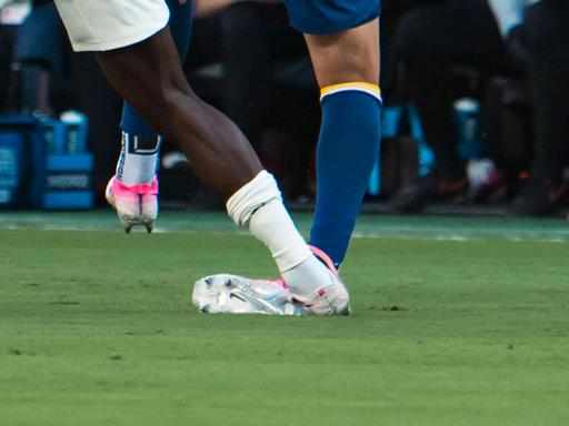 Beine von Fußballspielern während eines Zweikampfs, ein Spieler tritt dem anderen auf das Fußgelenk.