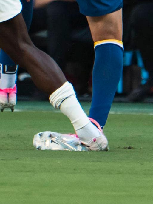 Beine von Fußballspielern während eines Zweikampfs, ein Spieler tritt dem anderen auf das Fußgelenk.