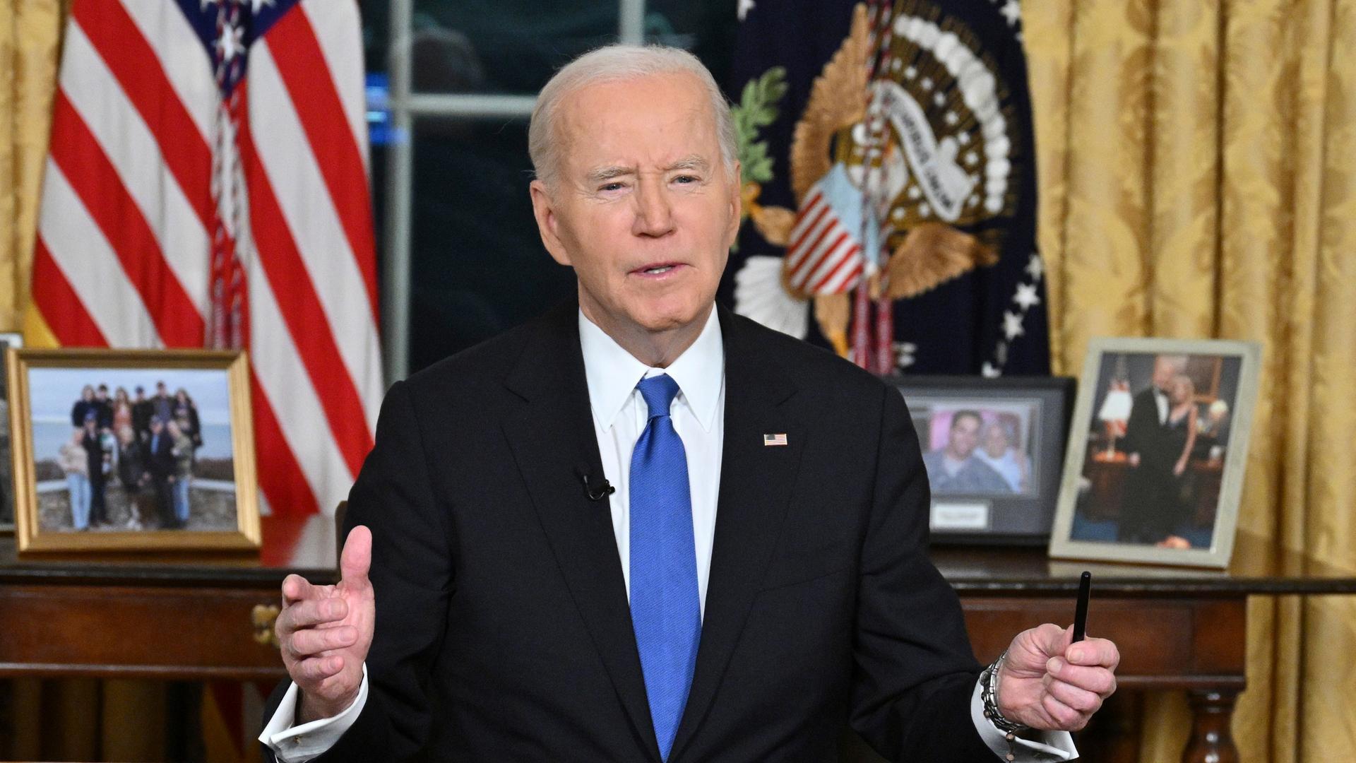 Joe Biden sitzt an einem Schreibtisch im Oval Office des Weißen Hauses