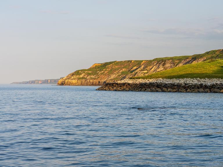 Ein Blick über die Nordseeküste und die Klippen am South Bay Beach in Scarborough, North Yorkshire, England