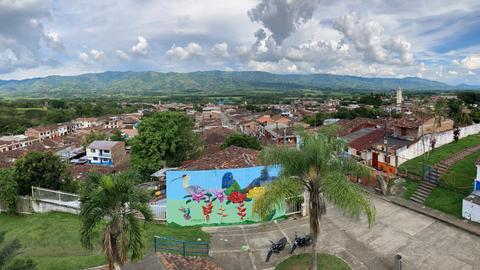 Ausblick über das Dorf Viterbo aus der Vogelperspektive. Im Hintergrund bewaldete Ausläufer des Gebirges.