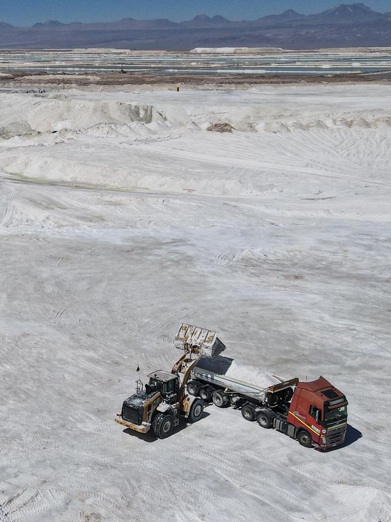 Arbeiter einer Lithiummine transportieren auf einem Lkw ein Nebenprodukt über den Salar de Atacama. Man sieht eine weiße Salzebene in der chilenischen Atacama-Wüste. Arbeiter einer Lithiummine transportieren auf einem Lkw ein Nebenprodukt über den Salar de Atacama. Man sieht eine weiße Salzebene in der chilenischen Atacama-Wüste.