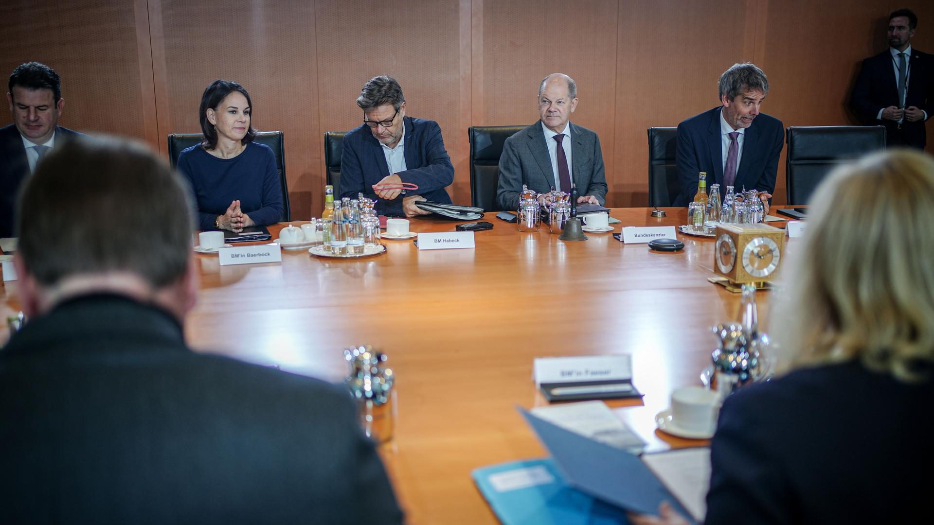Bundeskanzler Scholz sitzt mit den Ministern an einem Tisch.