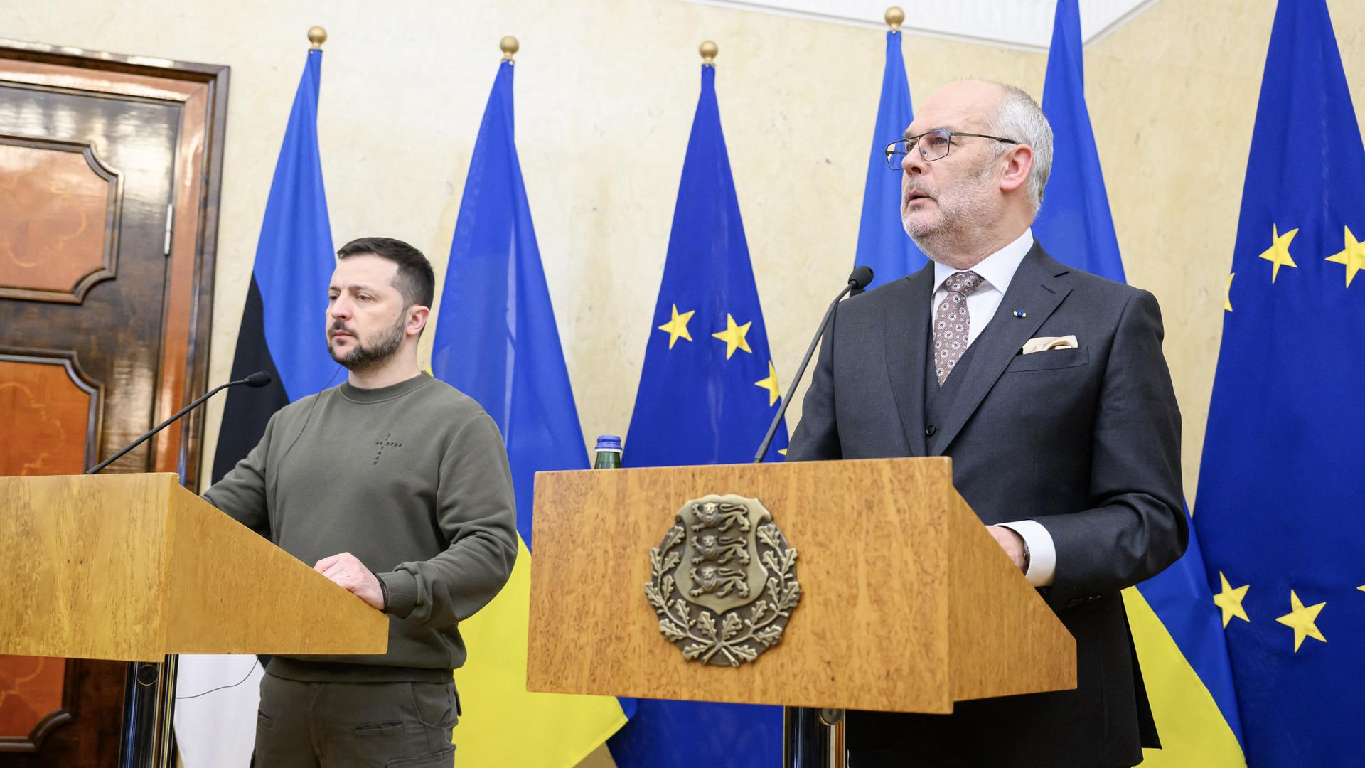 Der ukrainische Präsident Selenskyj und sein estnischer Amtskollege Karis stehen jhinter Rednerpulten. Hinter ihnen die ukrainische, die estnische und die EU-Fahne. 