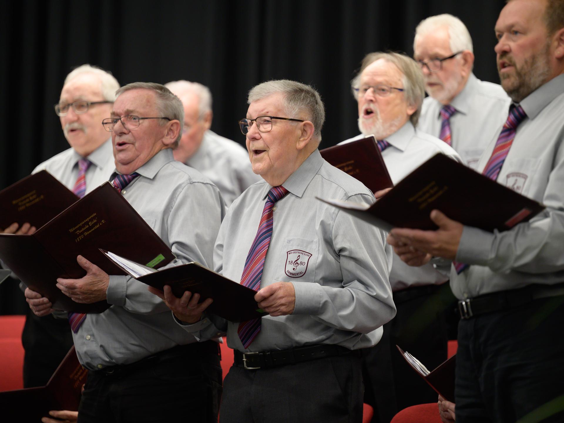 Sänger des Männergesangverein MGV Deutsche Eiche 1880 Hammertal stehen bei einem Konzert auf der Bühne und singen.