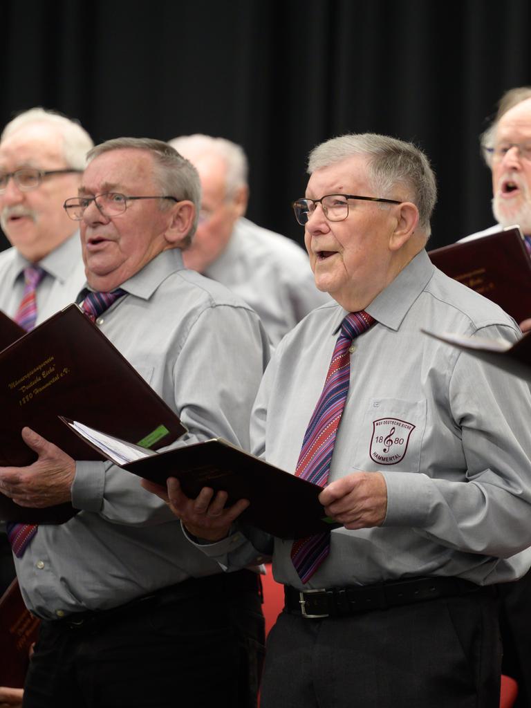 Sänger des Männergesangverein MGV Deutsche Eiche 1880 Hammertal stehen bei einem Konzert auf der Bühne und singen.