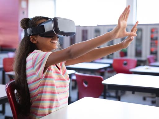Schülerin in den USA sitzt mit einer VR Brille im Klassenzimmer (Symbolbild)