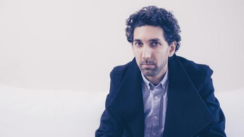 Der Komponist und Schlagzeuger Ketan Bhatti trägt einen Dreitagebart und blickt nachdenklich in die Kamera.