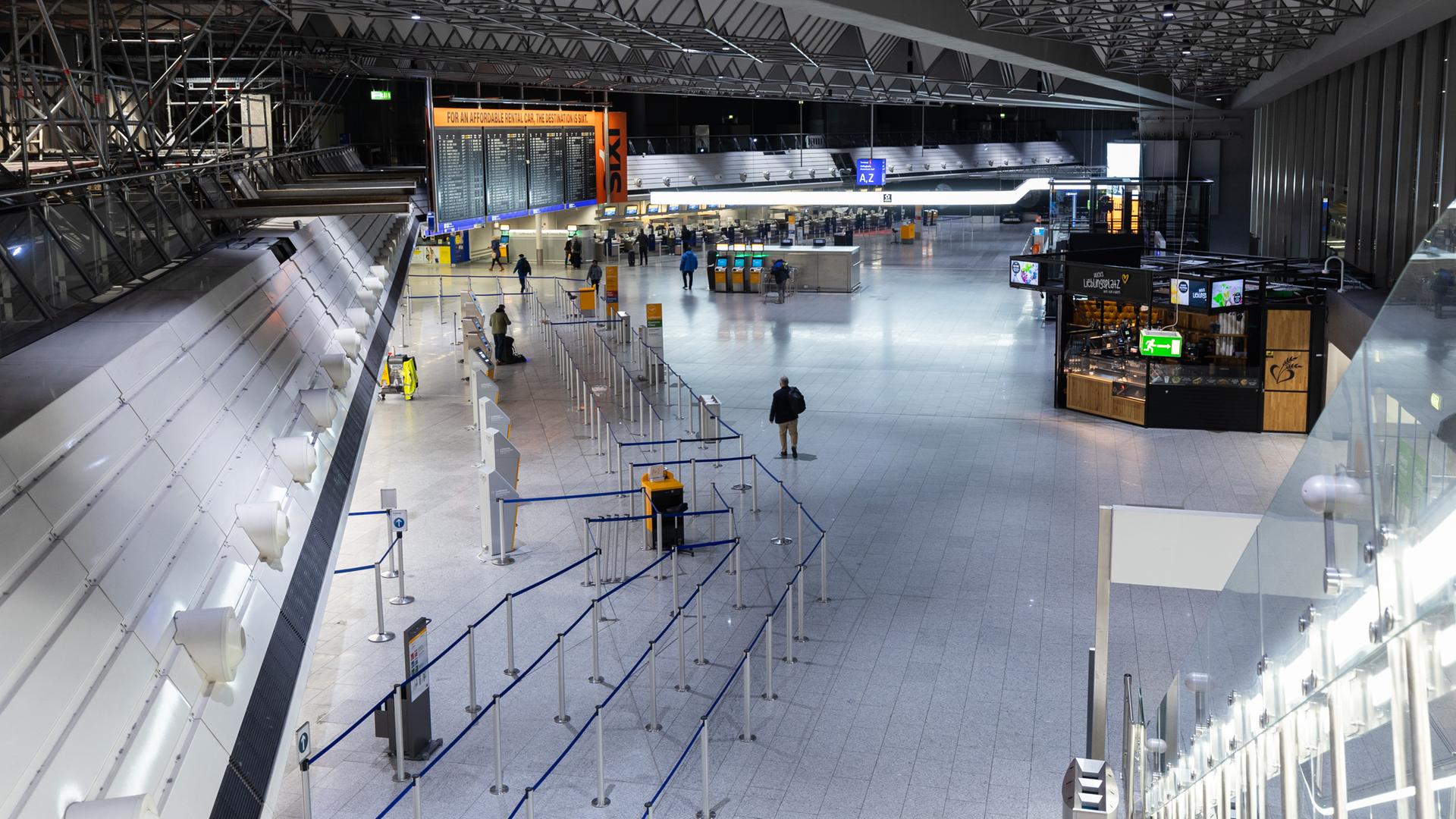 Frankfurt/M.: Wenige Passagiere gehen am Morgen durch die Abflughalle am Terminal 1 des Flughafen Frankfurt.