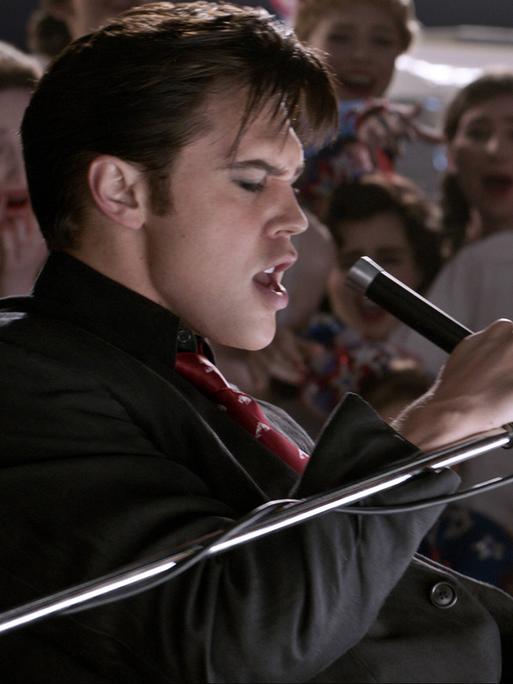 Austin Butler als Elvis Presley singend bei einem Auftritt.