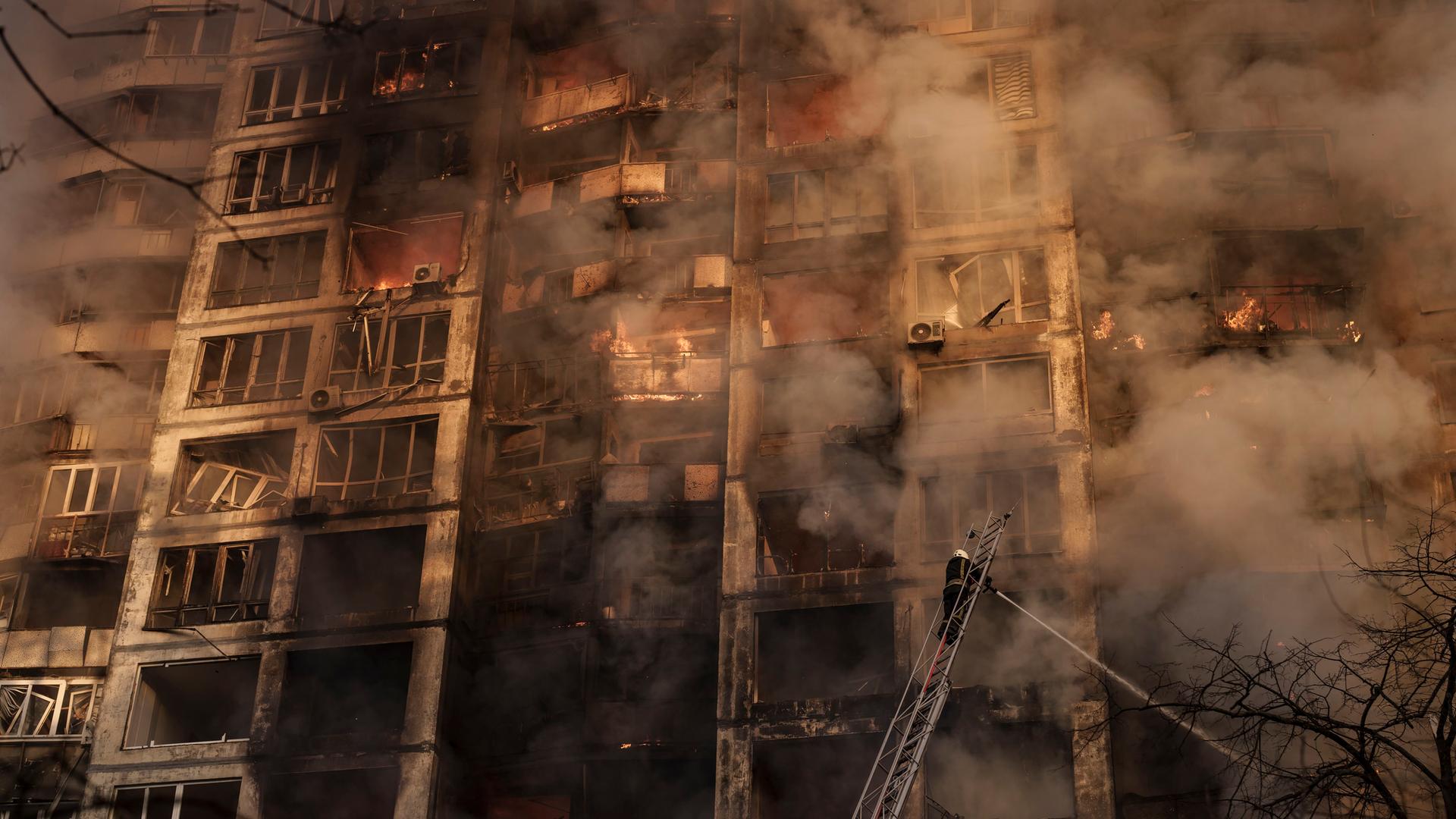 Feuerwehrleute löschen ein Wohnhaus in Kiew in der Ukraine, das von der russischen Armee beschossen wurde. Feuerwehrleute löschen ein Wohnhaus in Kiew in der Ukraine, das von der russischen Armee beschossen wurde.
