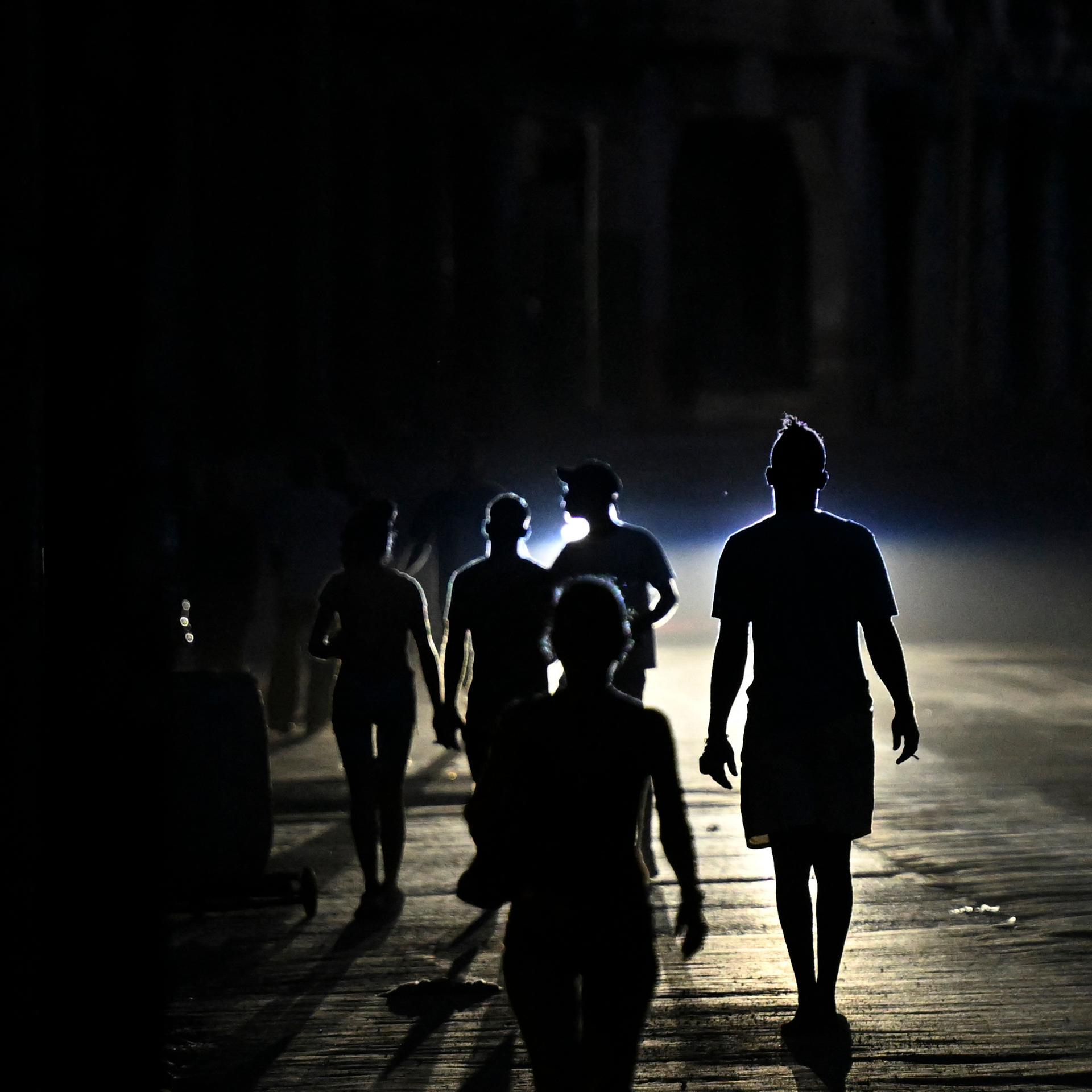 Menschen gehen während eines Stromausfalls in der kubanischen Hauptstadt Havanna auf der Straße spazieren.