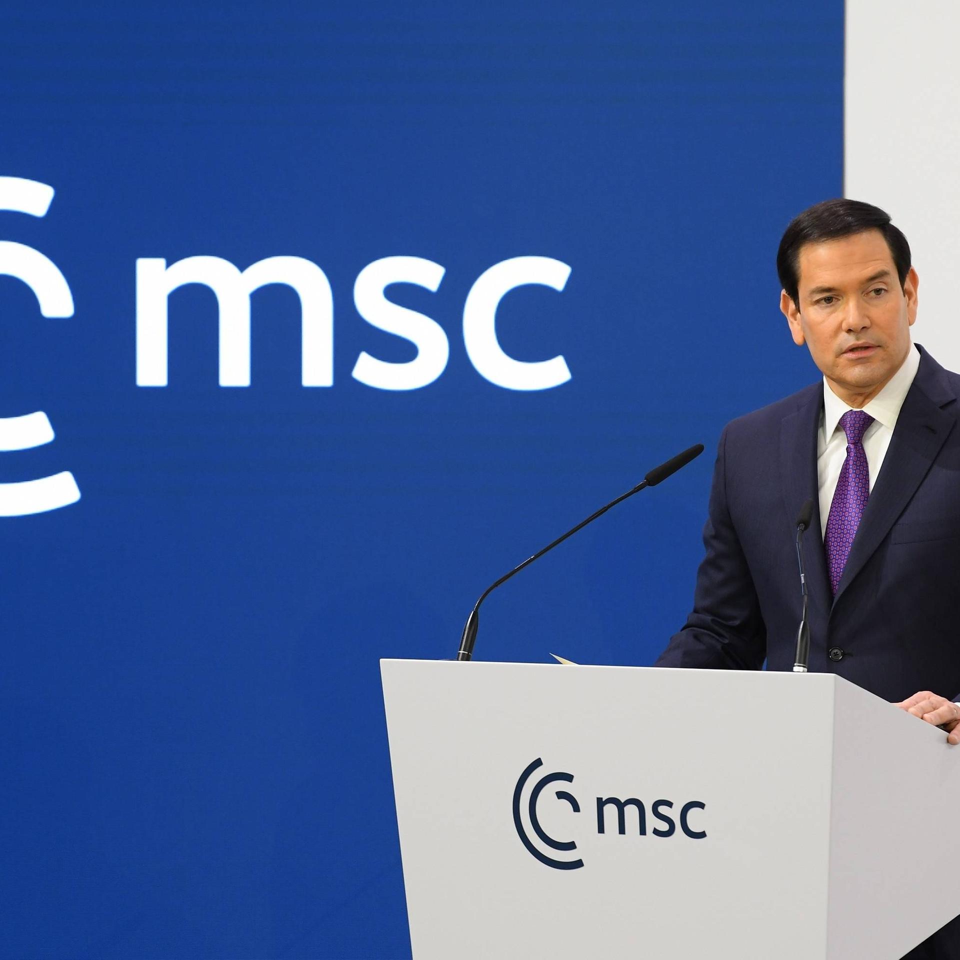 US-Außenminister Rubio steht auf der Münchner Sicherheitskonferenz an einem Rednerpult. Er hat den Kopf leicht geneigt, während er spricht. Links von ihm sieht man das Logo der Konferenz.