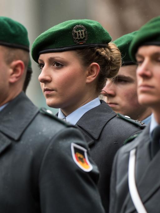 Eine Soldatin des Wachbataillons der Bundeswehr steht zusammen mit ihren Kollegen vor dem Bundeskanzleramt in Berlin.