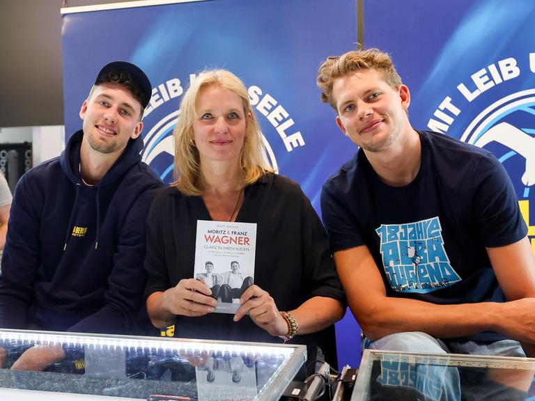 Franz Wagner (Orlando Magic) und Moritz Wagner (Orlando Magic) präsentieren das von Mutter Beate Wagner geschriebene Buch "Glanz in ihren Augen" Franz Wagner (Orlando Magic) und Moritz Wagner (Orlando Magic) präsentieren das von Mutter Beate Wagner geschriebene Buch "Glanz in ihren Augen"