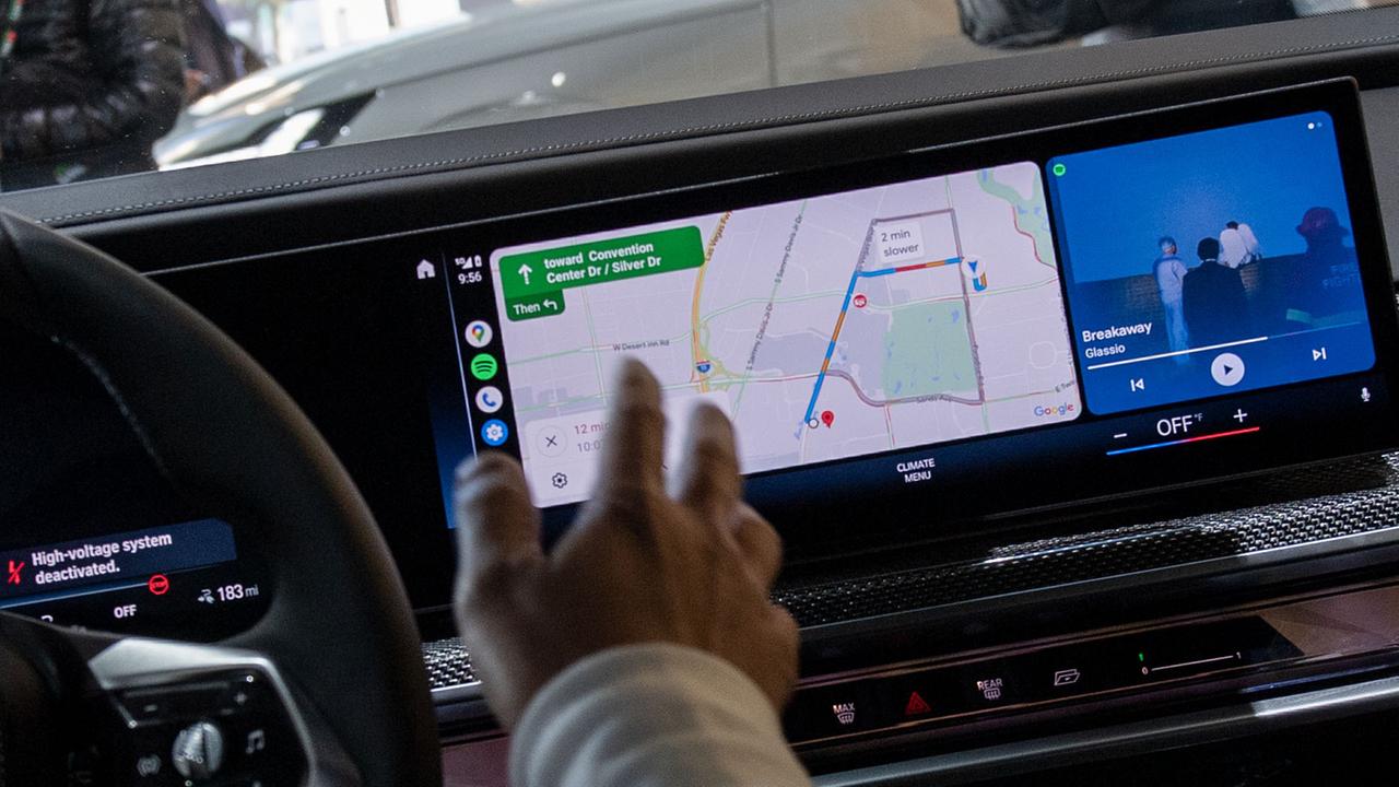 Eine menschliche Hand bedient ein Navigationssystem in einem Auto.