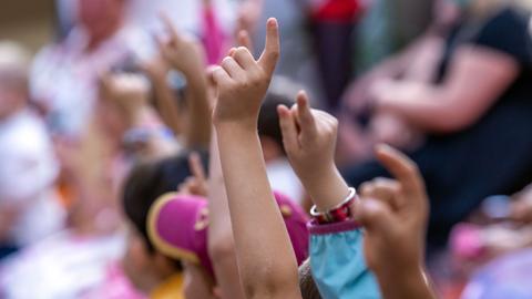 Jungen und Mädchen melden sich bei ihrer Einschulungsfeier in der Grundschule Lankow, Mecklenburg-Vorpommern. 