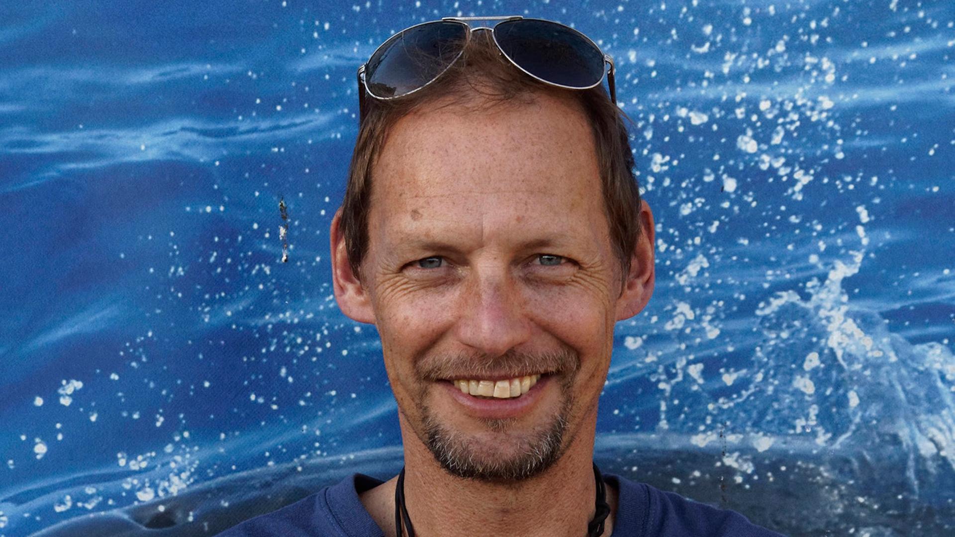 Fabian Ritter hält die Arme verschränkt und lächelt in die Kamera. Er trägt ein blaues T-Shirt und eine in die kurzen braunen Haare geschobene Sonnenbrille. Fabian Ritter hält die Arme verschränkt und lächelt in die Kamera. Er trägt ein blaues T-Shirt und eine in die kurzen braunen Haare geschobene Sonnenbrille.