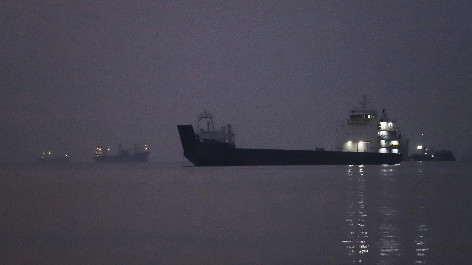 Vor Sonnenaufgang liegen Frachtschiffe in der Straße von Hormus vor Bandar Abbas vor Anker. Vor Sonnenaufgang liegen Frachtschiffe in der Straße von Hormus vor Bandar Abbas vor Anker.
