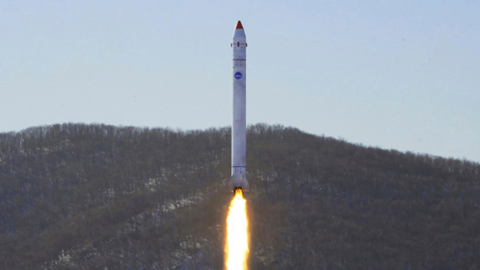 Dieses von der nordkoreanischen Regierung zur Verfügung gestellte Foto zeigt den angeblichen Test einer Rakete mit einem Testsatelliten auf dem Sohae-Satellitenstartplatz. Das Bild zeigt eine weiße Rakete, die senkrecht Richtung All abgehoben hat und einen Feuerschweif hinter sich herzieht.