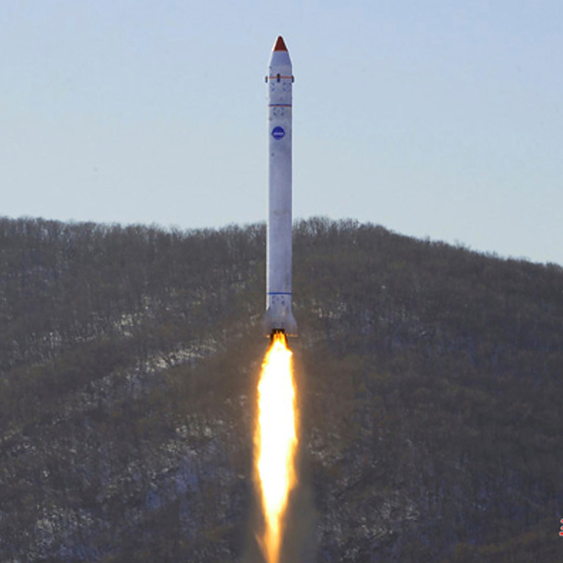 Dieses von der nordkoreanischen Regierung zur Verfügung gestellte Foto zeigt den angeblichen Test einer Rakete mit einem Testsatelliten auf dem Sohae-Satellitenstartplatz. Das Bild zeigt eine weiße Rakete, die senkrecht Richtung All abgehoben hat und einen Feuerschweif hinter sich herzieht.