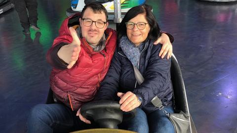 Stefanie Ulrich sitzt mit ihrem erwachsenen Sohn Johannes in einem Autoscooter.