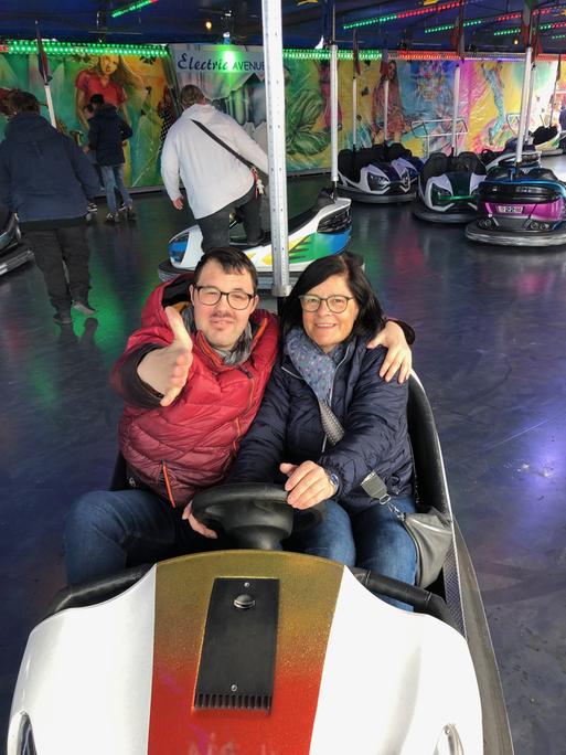 Stefanie Ulrich sitzt mit ihrem erwachsenen Sohn Johannes in einem Autoscooter.