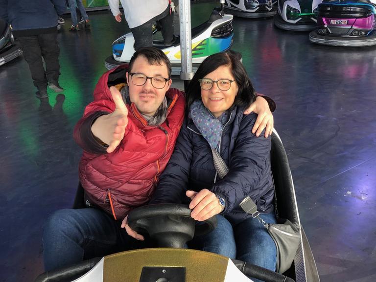 Stefanie Ulrich sitzt mit ihrem erwachsenen Sohn Johannes in einem Autoscooter.