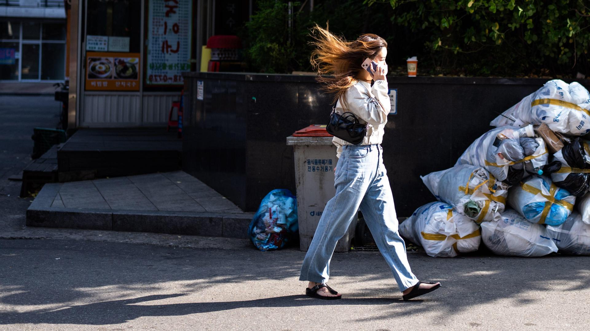 In Seoul, der Hauptstadt Südkoreas, läuft eine Frau eine Straße entlang und telefoniert.