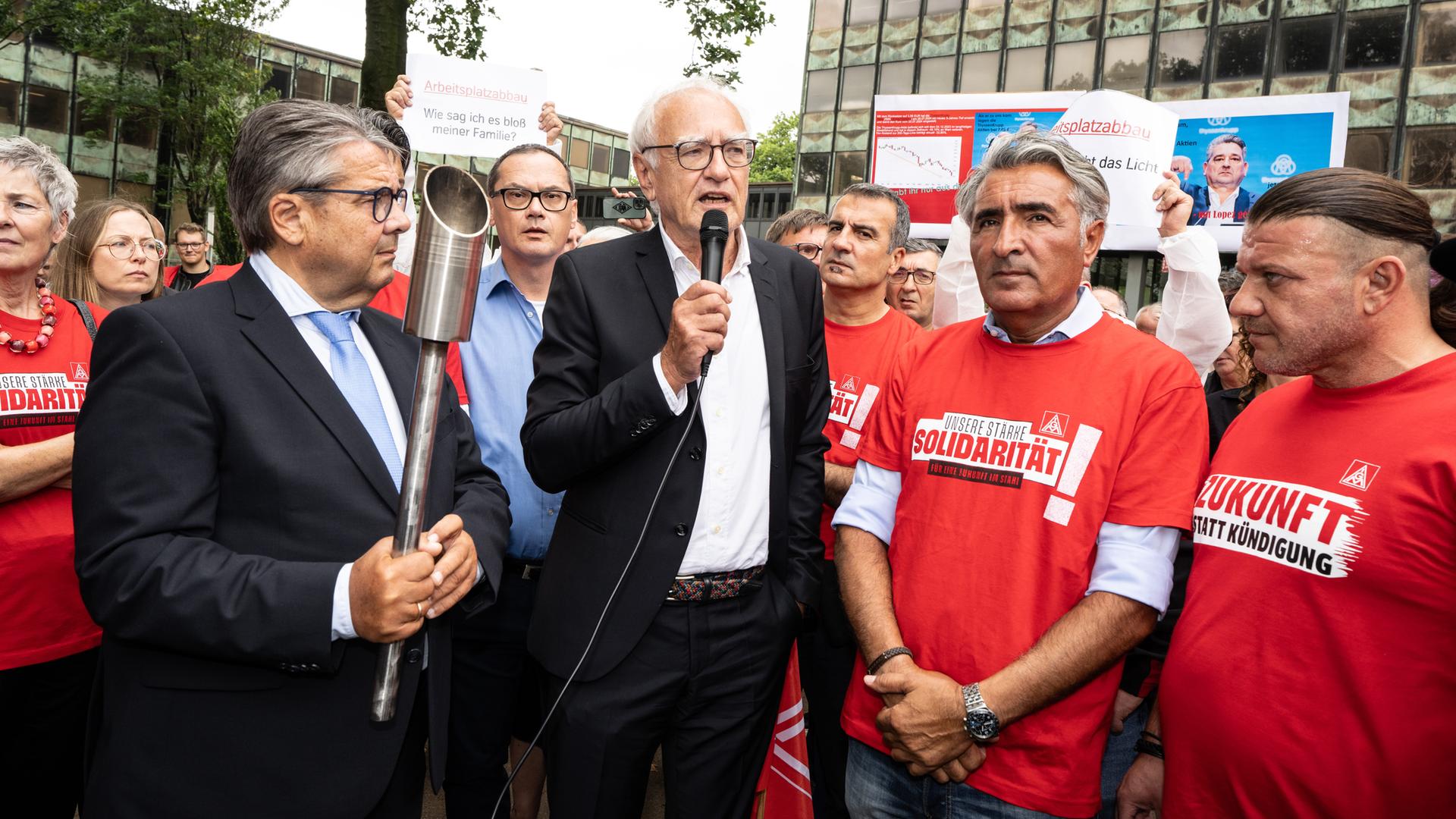 Der Aufsichtsratsvorsitzende von ThyssenKrupp-Steel, Gabriel, (l.) legt sein Amt nieder. Er steht neben seinem Stellvetreter Detlef Wetzel und Mitarbeitern des Konzerns.