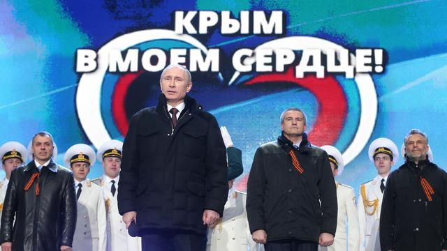 Russlands Präsident Wladimir Putin (vorn) mit Politikern und Soldaten von der annektierten Halbinsel Krim bei einer Feier auf dem Roten Platz in Moskau.