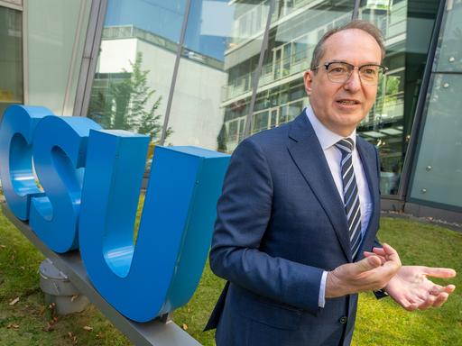 Der designierte Bundesinnenminister Alexander Dobrindt steht im Innenhof der CSU-Parteizentrale neben dem CSU-Logo.