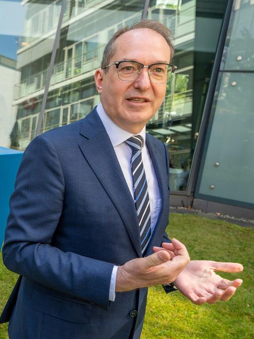 Der designierte Bundesinnenminister Alexander Dobrindt steht im Innenhof der CSU-Parteizentrale neben dem CSU-Logo.