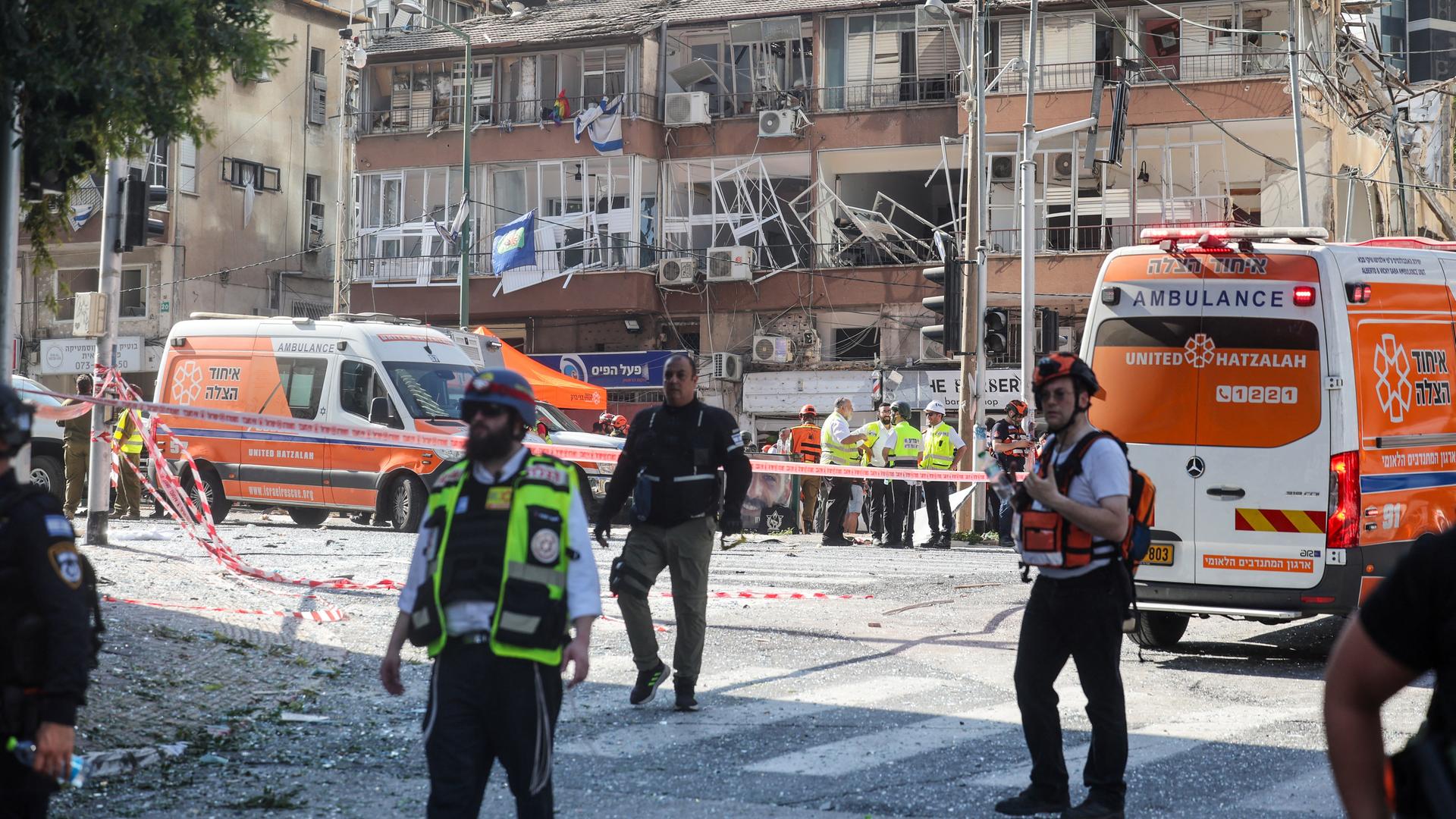 Rettungskräfte stehen vor einem stark beschädigten Gebäude, ein Teil des vorgelagerten Platzes ist abgesperrt. Rettungskräfte stehen vor einem stark beschädigten Gebäude, ein Teil des vorgelagerten Platzes ist abgesperrt.