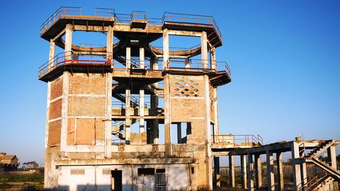 Ein verfallender Industrieturm vor blauem Himmel